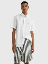 Camisa blanca de manga corta confeccionada en popelín de puro algodón, con cuello abotonado, corte regular y logo de Tommy Hilfiger bordado en el pecho.