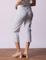 Pantalón capri marca Zac & Rachel, confeccionado en gabardina elastizada a rayas verticales celestes y blancas. Presenta pretina ancha elastizada y ruedo con bordado floral.