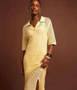Vestido midi color amarillo pálido con efecto crochet, cuello polo, manga corta y abertura lateral. Confeccionado en algodón BCI más sostenible.