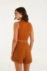 Top color beige, corte crop, con escote redondo y tirantes anchos.