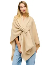 Ruana de tejido soft color beige, con cuello en V y un lazo o pasador frontal para ajustar. El ruedo tiene terminación desflecada.