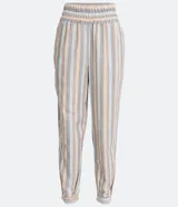 Conjunto de pantalón y blusa de algodón a rayas verticales en tonos beige, celeste y blanco. El pantalón es de corte recto con cintura elástica y puños ajustados. La blusa es de corte crop con escote en V y mangas cortas abullonadas.