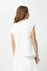 Blusa blanca de mangas cortas con bordado floral en el frente.