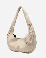 Bolso hobo color crema con tachas plateadas y cierre con botón magnético.