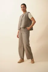 Chaleco marrón con solapas amplias y terminaciones envivadas. Diseño reversible y sin mangas.