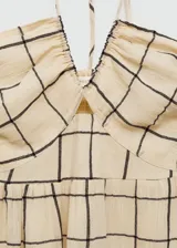 Vestido largo color crema con estampado de cuadros marrones, cuello halter y tirantes finos.