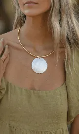 Gargantilla dorada con cadena snake y dije circular de nácar.