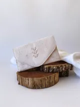 Billetera de cuero color crudo con textura, cierre con broche y monedero externo.