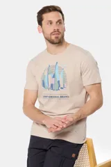 Remera de manga corta color beige jaspeado con cuello redondo. Presenta un estampado frontal de veleros en tonos azules y rosados, con el texto "LEGKY ORIGINAL BRAND SAILING" debajo.