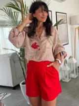 Short rojo de lino con pinzas, tiro alto y corte holgado.