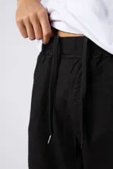 Pantalón de lino color beige, de corte recto y holgado, con cintura elastizada y cordón ajustable. Presenta bolsillos laterales amplios.