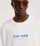 Remera oversize blanca de algodón con cuello redondo y mangas cortas. Estampa lettering "Unbeatable" en azul en el frente.