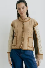 Chaqueta tejida en lana merino y lambswool color negro, con detalles bordados en beige y marrón.