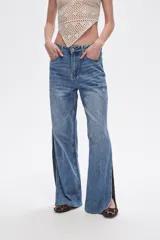 Pantalón de jean azul de tiro alto, corte recto y aberturas laterales en el ruedo.