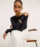 Pulsera dorada rígida con forma de gota doble.