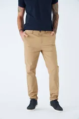 Pantalón chino de gabardina color beige, de corte regular, con cierre de botón y bragueta, y bolsillos delanteros y traseros.