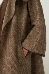 Tapado marrón de largo medio, abierto, con cuello y envivado. Hecho 100% en Uruguay con tela 100% lana fina sin teñir, diseñada exclusivamente por Don Baez.