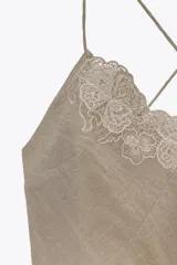 Vestido midi color beige de estilo lencero, con escote en V, tirantes finos cruzados en la espalda y detalle de bordados florales a tono en el escote y lateral.