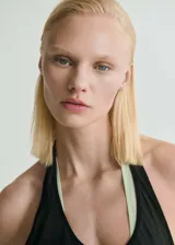 Vestido largo negro semitransparente con cuello redondo y sin mangas.