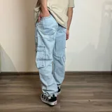 Pantalón jean color beige, corte recto y estilo cargo con bolsillos laterales.