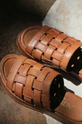 Sandalias bajas color suela, con diseño de tiras anchas entretejidas en el empeine.