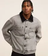 Campera trucker boxy de jeans gris con cuello de terciopelo negro, abotonada al frente, con bolsillos delanteros y mangas largas ajustadas.