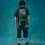 Remera negra de corte oversize con efecto gastado y estampa pequeña en el pecho de una parrilla con fuego y el texto "Kaboa Industries".