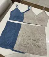 Conjunto deportivo celeste compuesto por un top con breteles finos y calza corta con cintura alta.