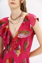 Vestido mini color fucsia con estampado de hojas multicolor, escote en V con volados, sin mangas y falda acampanada.
