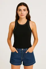 Musculosa negra de algodón y elastano, corte ajustado, con cuello redondo y tachas plateadas en cuello y sisas.