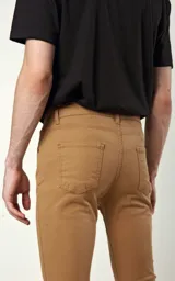 Pantalón de gabardina elastizada color camel, de calce skinny fit, con bolsillos delanteros y traseros.