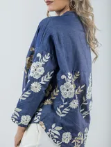 Camisa de jean azul con bordado de flores en tonos champagne y cobre, cuello mao y corte amplio.