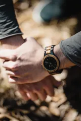 Reloj Vernoir con caja de madera de Zebrano y malla de Chacate Preto con incrustaciones de madera de Zebrano. Esfera negra con marcadores minimalistas en blanco y manecillas negras.
