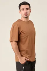 Remera marrón de corte holgado con estampado de un ave y texto en la espalda.