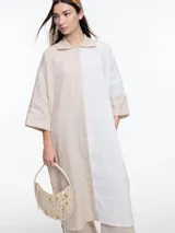 Vestido camisero largo de lino, con manga 3/4 y silueta relajada. Diseño con bloques de color en contraste blanco y negro.