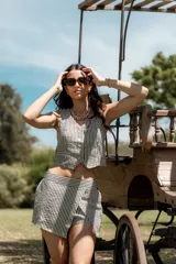 Conjunto de short y chaleco a rayas verticales en blanco y negro. El chaleco es corto con botones al frente y el short es de tiro alto con corte cruzado.