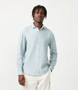 Camisa celeste de lino con cuello camisero, abotonadura frontal y mangas largas.