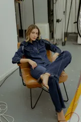 Camisa/chaqueta de denim azul con volados en el frente y en las mangas.