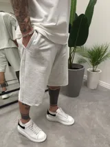 Bermuda deportiva gris de algodón, corte holgado con bolsillos laterales.