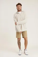 Sweater de punto color crema con cuello alto y cierre de cremallera parcial. Diseño de corte holgado y mangas largas.