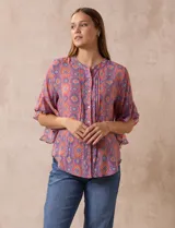 Blusa de gasa estampada con cuello a la base, abertura central con botones y mangas cortas con volados.