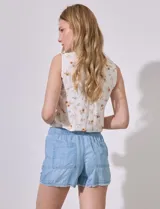 Short de tencel color blanco, con pretina elástica, lazo de ajuste y terminaciones desflecadas.
