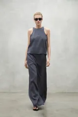 Pantalón de lino color beige, de pierna ancha, cintura elástica y bolsillos laterales.