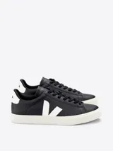 Zapatilla de cuero negro con detalles blancos en el logo, diseño clásico y comodidad.