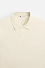 Polo color crema de manga larga con cuello solapa y cierre frontal de botonadura.