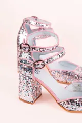 Zapato de tacón plateado con glitter, punta cuadrada, doble tira con hebilla al tobillo y forro rosa.