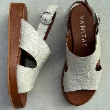 Sandalias de cuero color blanco con textura tipo reptil, plataforma marrón y hebilla metálica plateada.