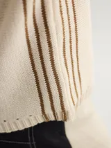 Chaleco tejido color crema con cuello redondo y rayas verticales marrones.