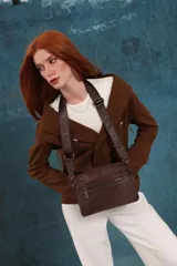 Bandolera color rosa viejo con detalles en cuero marrón claro, múltiples cremalleras metálicas y herrajes plateados. Incluye correa ancha ajustable con el logo de la marca.