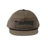 Gorro de visera Thrasher color verde oliva con logo bordado en negro y cordón decorativo negro.